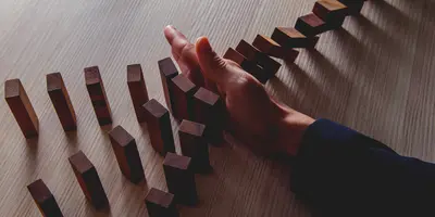 hand stopping dominos